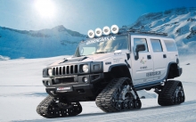 Белый Hummer H2 на гусеницах в снежной горной долине